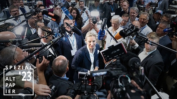 Die AfD-Politikerin Alice Weidel ist von Journalisten mit Kameras und Mikrofonen umringt.