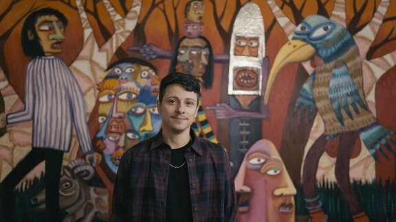 Maler Oska Gutheil vor einem bunten Wandbild