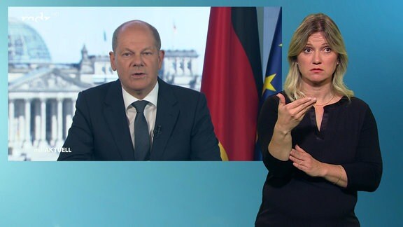 Gebärdendolmetscherin im Studio, dahiner Bundeskanzler Olaf Scholz