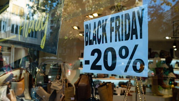 Ein Black-Friday-Schild mit 20 % Rabatt ist in einem Schaufenster zu sehen.