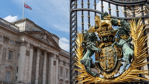 Frontansicht des Buckingham Palace in London mit dem Wappen des Vereinigten Königreichs