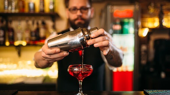Ein Barkeeper macht einen Cocktail