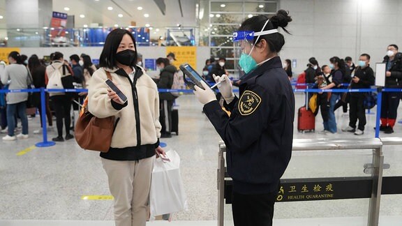Eine Mitarbeiterin der Zollbehörde des internationalen Flughafens Shanghai prüft die Daten einer ankommenden Passagierin