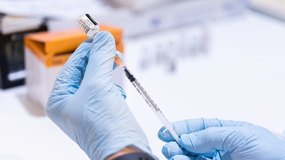 Ein Mitarbeiter eines mobilen Impfteams vom Arbeiter-Samariter-Bund (ASB) zieht eine Spritze mit dem BA.4/BA.5-Impfstoff von BioNTech/Pfizer gegen das Corona-Virus (SARS-CoV-2) im Impfzentrum auf.