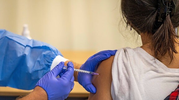 Eine Schülerin wird vom mobilen Impfteam in der Schule geimpft