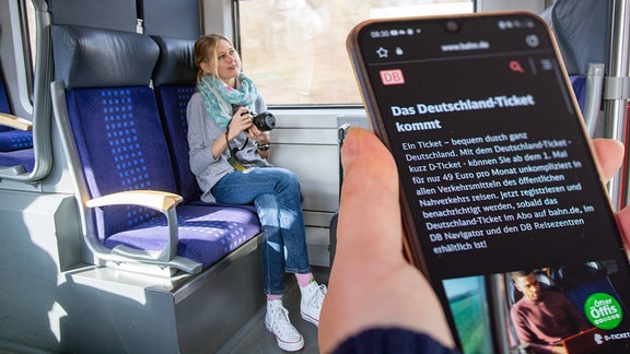 Deutschlandticket, 49-Euro-Ticket: Nahaufnahme eines Smartphones in einem Regionalzug 