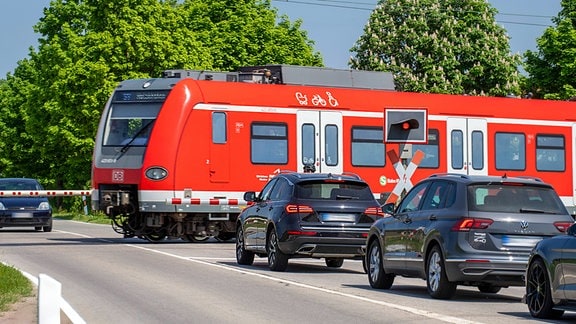 S-Bahn überquert beschrankten Bahnübergang