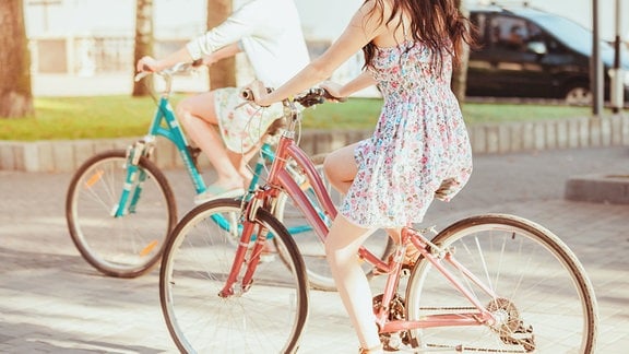 Zwei Menschen fahren Fahrrad im Sommer