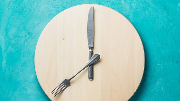 Messer und Galbel liegen auf einem runden Holzbrettchen.