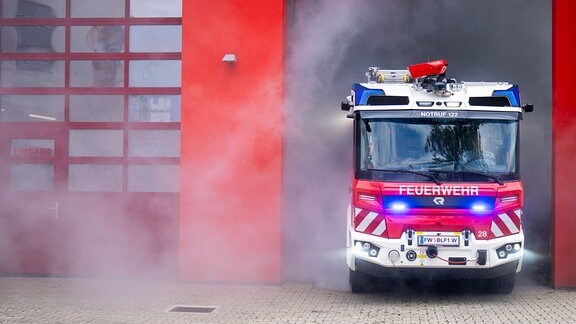 Ein Einsatzfahrzeug der Feuerwehr fährt aus einer Feuerwache.