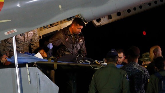 Militärangehörige laden einen der vier indigenen Geschwister, die nach einem tödlichen Flugzeugabsturz vermisst wurden, auf dem Militärflughafen aus einem Flugzeug aus. 