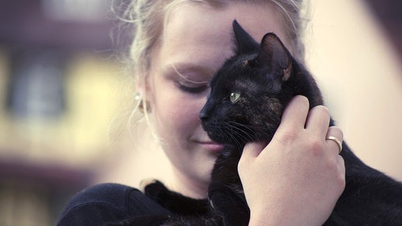 Eine junge Frau mit einer schwarzen Katze