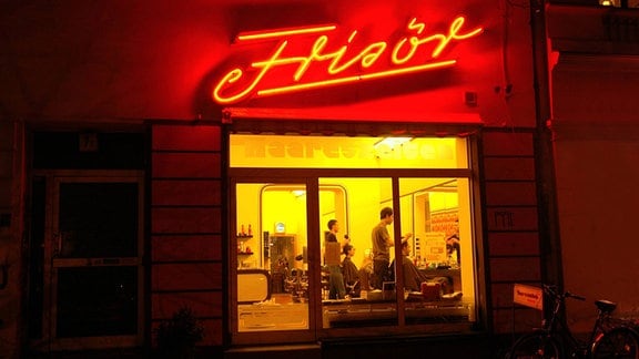 Abendlicht: Beleuchteter Friseursalon in Berlin