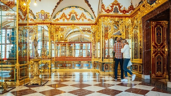 Besucher schauen sich in einem reich verzierten Raum, der als Juwelenzimmer des Historischen Grünen Gewölbes bekannt ist, um.