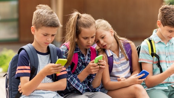 Kinder schauen auf ihre Smartphones
