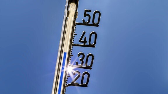 Thermometer vor wolkenlosen Himmel zeigt 7°C