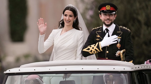 Die saudische Architektin Rajwa Alsaif (l) und der jordanische Kronprinz Hussein bin Abdullah II fahren anlässlich ihrer Hochzeit in einem offenen Wagen durch Amman.