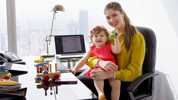 Frau mit Kind am Schreibtisch