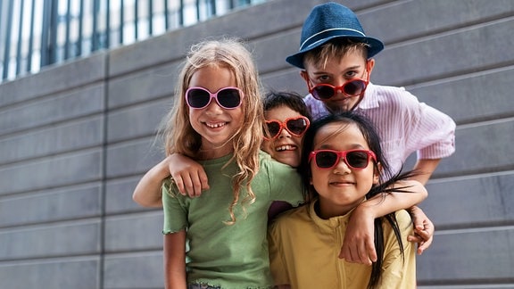 Kinder mit lustigen Brillen posieren vor der Kamera