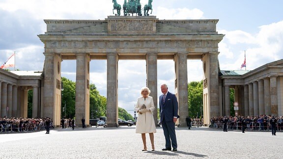Der britische Thronfolger Prinz Charles und seine Frau Herzogin Camilla stehen auf dem Pariser Platz vor dem Brandenburger Tor.