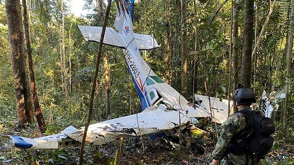 Auf diesem von der Pressestelle der kolumbianischen Streitkräfte veröffentlichten Bild steht ein Soldat vor dem Wrack einer Cessna C206, die am 18. Mai 2023 im Dschungel von Solano im kolumbianischen Bundesstaat Caqueta abgestürzt ist