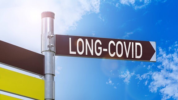 Auf einem Straßenschild steht Long Covid.