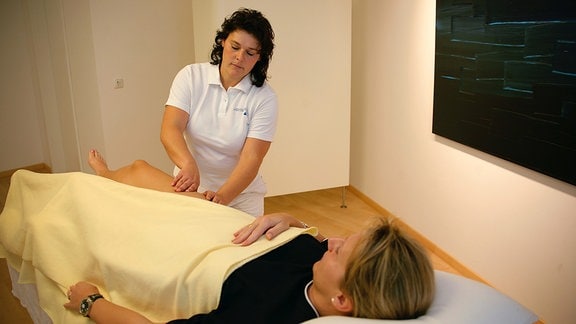 Physiotherapeutin führt Lymphdrainage an Patientin durch.