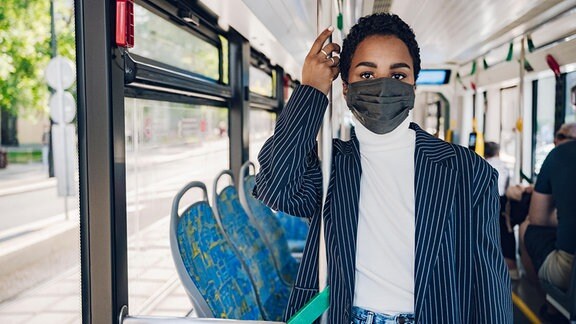 Frau mit Maske in Bus