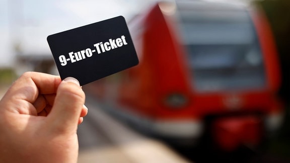 Symbolfoto: 9-Euro-Ticket, dahinter ein Regionalzug