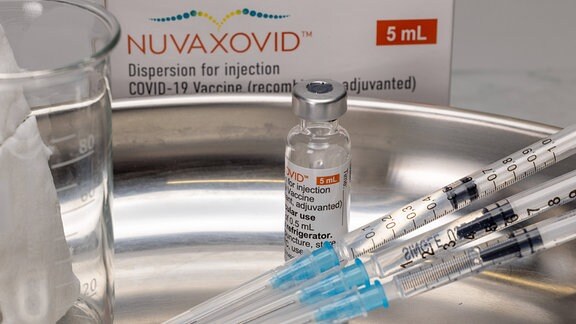 Originale Impfstoff-Phiole Nuvaxovid von Novavax mit Spritzen und Verpackung