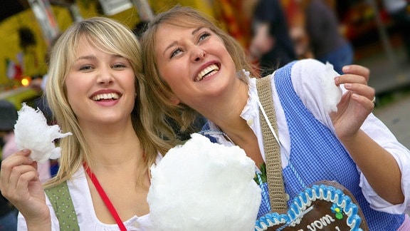 Zwei blonde Mädchen auf dem Münchener Oktoberfest mit Lebkuchenherzen in den Händen.