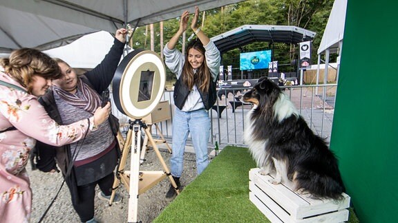 Selfiestation für Hunde, zwei Frauen animieren einen Hund in die Kamera zu schauen