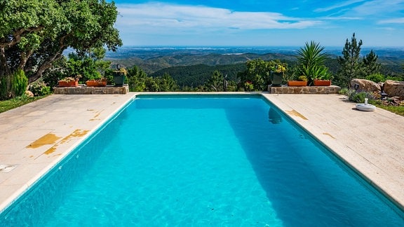Ein Pool, dahinter Aussicht auf hügelige Landschaft