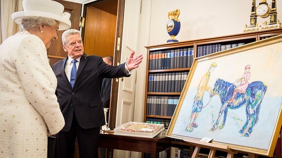 Joachim Gauck zeigt Königin Elizabeth II. 2015 ein Gemälde ihres Pferdes. 