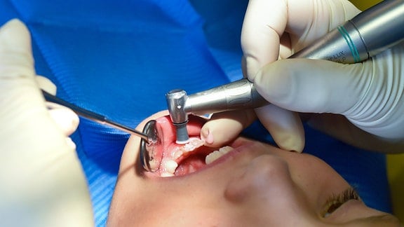 Ein Mädchen wird von einer Zahnärztin behandelt. 