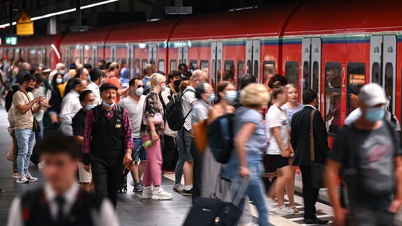 Zugreisende steigen in eine S-Bahn ein