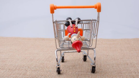 Pinocchio hängt an einem Einkaufswagen