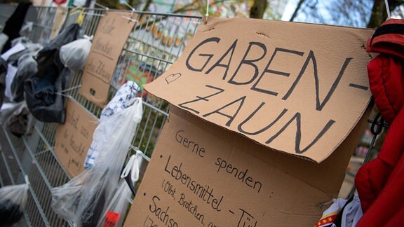 Lebensmittel, Kleidung und kleine Geschenke für Bedürftige hängen an einem sogenannten Gabenzaun im Bremer "Viertel".