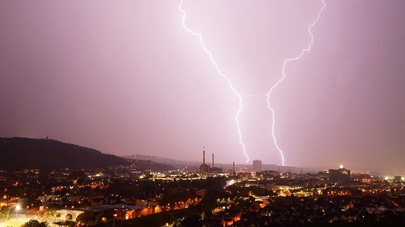 Zwei Blitze entladen sich während eines Gewitters hinter dem Gaskessel in Stuttgart.