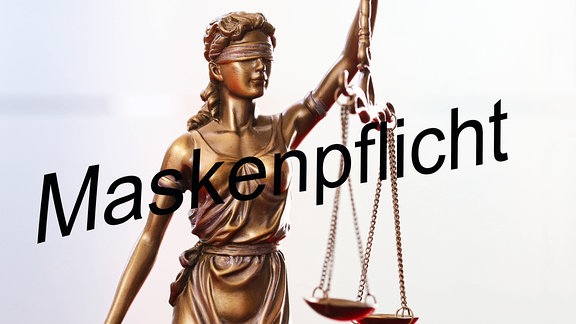 Symbolbild Klage gegen Coronamaßnahme - Figur der Justitia - Darüber das Wort - Maskenpflicht