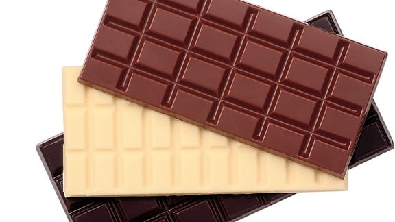 Schokoladentafeln in Zartbitter, Weiß und Vollmilch liegen übereinander