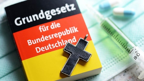 Deutsches Grundgesetzbuch, Kreuz, Tabletten und Spritze, Symbolfoto Sterbehilfe