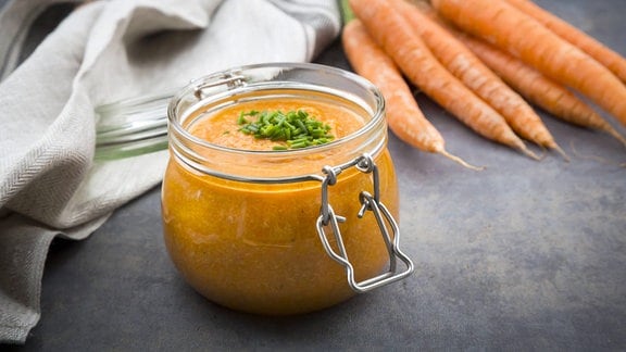 Glas Süßkartoffel-Möhren-Suppe mit Schnittlauch garniert.