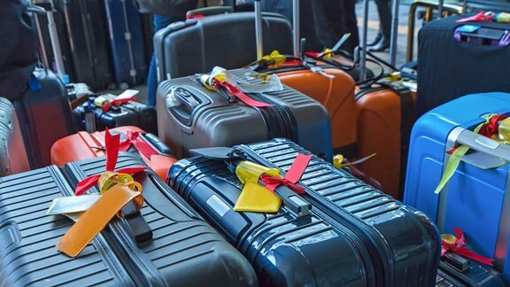Mehrere Koffer mit Banderolen stehen nebeneinander