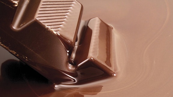Schokoladenriegel taucht in flüssige Kuvertüre