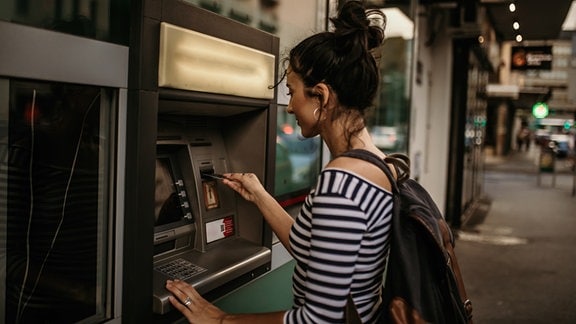 Frau an einem Bankautomat