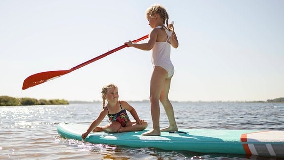 Kinder auf einem Stand-Up-Paddle.