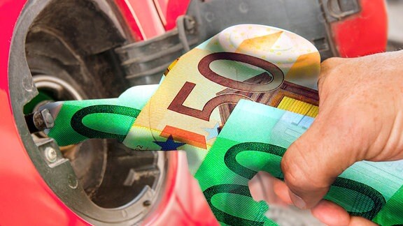 Tanken an einer Tankstelle, Detail Hand mit Zapfpistole, symbolisch umhüllt von Geldscheinen