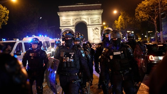 Polizisten patrouillieren vor dem Arc de Triomphe auf der Champs Elysees. 