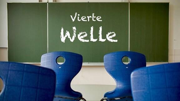 Schulwandtafel mit der Aufschrift "Vierte Welle" in einem Klassenzimmer